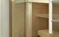 Hohe Einbausauna mit integriertem Gebäudefenster - Waagerechte Innenverkleidung und Saunabänke in Espe - Lehnen, Ofenschutz und äußerer Rahmen in Eiche - Saunabänke