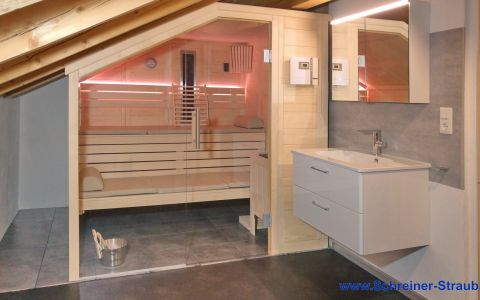 Sauna aus massivem Fichtenholz mit Dachschräge; Einrichtung in Linde mit LED-Lehnenbeleuchtung und Infrarotstrahler - Außenansicht
