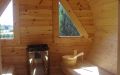 Große Fass-Sauna aus skandinavischer Fichte mit Vorraum, Einrichtung in Espe - Innenansicht, Fenster, Saunaofen, rechte Saunabank und Aufgusseimer