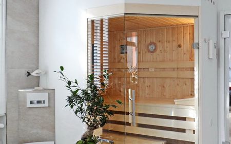 Badezimmer-Sauna mit abgeschrägter Eckverglasung, Innenverkleidung in Fichte, Einrichtung in Espe