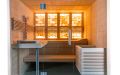 Massivholz-Sauna aus Fichte mit Glasfront, Infrarotstrahler und beleuchteter Salzsteinwand - Rückwand weiß beleuchtet