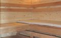 Sauna mit Eckeinstieg, Wandverkleidung aus waagerechten Zirbenholz-Profilen, Einrichtung in Thermo-Espe - Innenansicht mit Eckleuchte