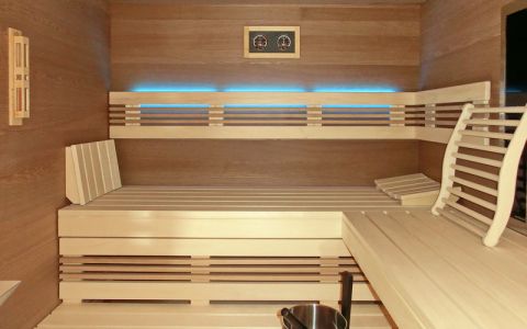 Einbausauna mit Glasfront und Infrarotstrahler, Holzoberflächen in Eiche, Einrichtung in Espe / Eiche - LED-Lehnenbeleuchtung, türkis - Saunabänke