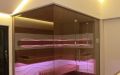 Glassauna mit Eckverglasung, Holzflächen in Wildeiche, Einrichtung in Thermo-Espe - LED Bank- und Rückenlehnenbeleuchtung, pink, gedimmte Saunaraum-Beleuchtung