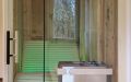 Kleine Badezimmer-Sauna mit abgeschrägter Glasfront; Innenverkleidung aus Altholzprofilen in Fichte, Tanne, Kiefer - farbige LED-Liegenbeleuchtung