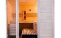 Massivholz-Sauna aus Fichte mit Eckeinstieg, Ganzglaselement, Infrarotstrahler und beleuchteter Salzsteinwand - Seitenansicht