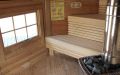Saunakota aus Rundbohlen in Polarkiefer, Einrichtung in Espe - Innenansicht, Fenster, Saunabänke, holzbefeuerter Saunaofen von Harvia
