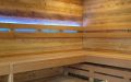 Große Wellness-Sauna mit Glasfront, integriertem Gebäudefenster und Sternenhimmel; Innen- und Außenverkleidung aus Altholzprofilen in Fichte, Tanne, Kiefer; Einrichtung in Thermo-Espe mit LED-Lehnenbeleuchtung - Innenansicht, Saunabänke