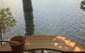 Fasssauna aus Rotzedernholz mit Panoramaverglasung aus Acrylglas - Panoramaaussicht durch die Verglasung auf einen See