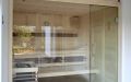 Massivholz-Sauna in Fichte mit Glasfront und Einrichtung in Nussbaum-Design