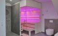 Badezimmersauna mit Dusche und Eckverglasung, waagerechte Innenverkleidung in Espe mit Nussbaumfugen, Einrichtung in Espe - Totalansicht, LED-Beleuchtung, pink