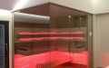 Glassauna mit Eckverglasung, Holzflächen in Wildeiche, Einrichtung in Thermo-Espe - LED Bank- und Rückenlehnenbeleuchtung, rot