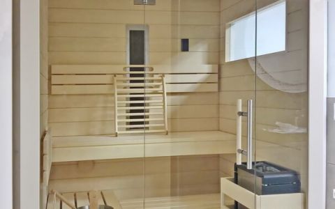 Kleine Sauna mit Infrarotstrahler, Glasfront, Fenster und weißer Außenverkleidung - Innenverkleidung und Einrichtung in Espe - Ansicht von vorne