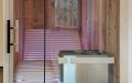 Kleine Badezimmer-Sauna mit abgeschrägter Glasfront; Innenverkleidung aus Altholzprofilen in Fichte, Tanne, Kiefer - Saunaofen