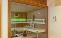 Einbausauna mit Glasfront und Infrarotstrahler, Holzoberflächen in Eiche, Einrichtung in Espe / Eiche - LED-Lehnenbeleuchtung, grün - Ansicht von schräg links